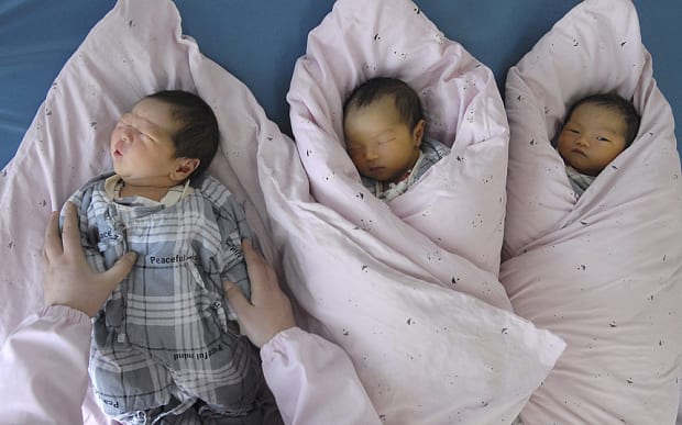 A nurse takes care of newborn infants at a hospital in Huai'an, Jiangsu province