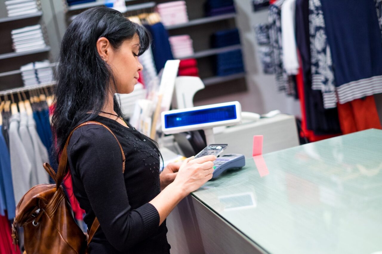 Girl Making Mobile Payment in Store