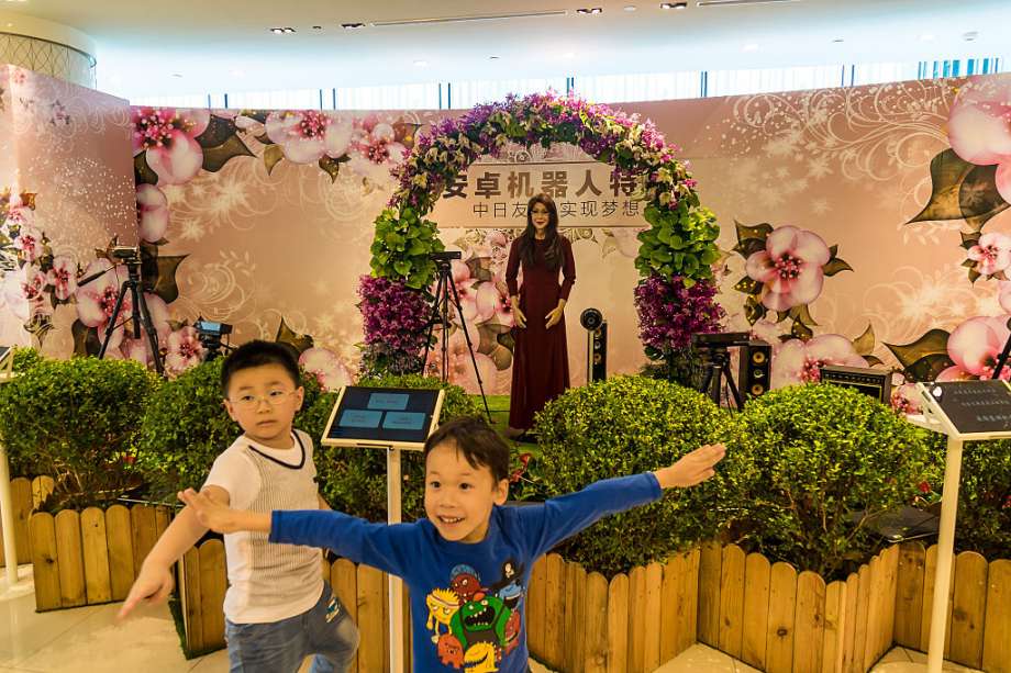 At the Takashimaya Department Store in Shanghai, children react in front to an android that could speak, sing, shake hands and hug with people. Photo: Getty Images, Visual China Group / 2015 Visual China Group