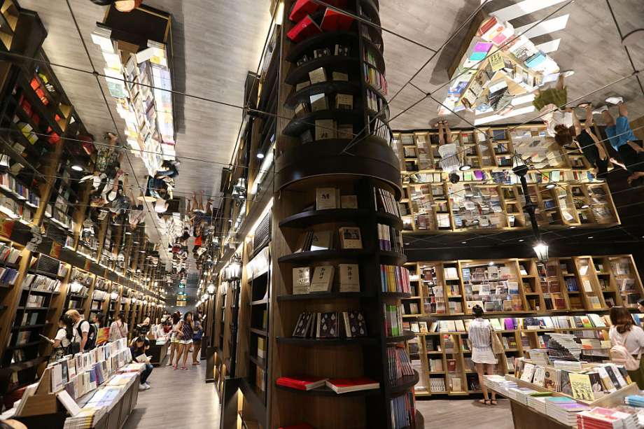 The new Zhongshuge bookstore at Reel Department store in Shanghai, China. The bookstore chain goes to great lengths to make itself attractive: Interior wooden shelves are painted in a spectrum of bright colors, and ceiling lights are arranged to suggest a starry sky. Photo: Getty Images, Visual China Group / 2016 VCG